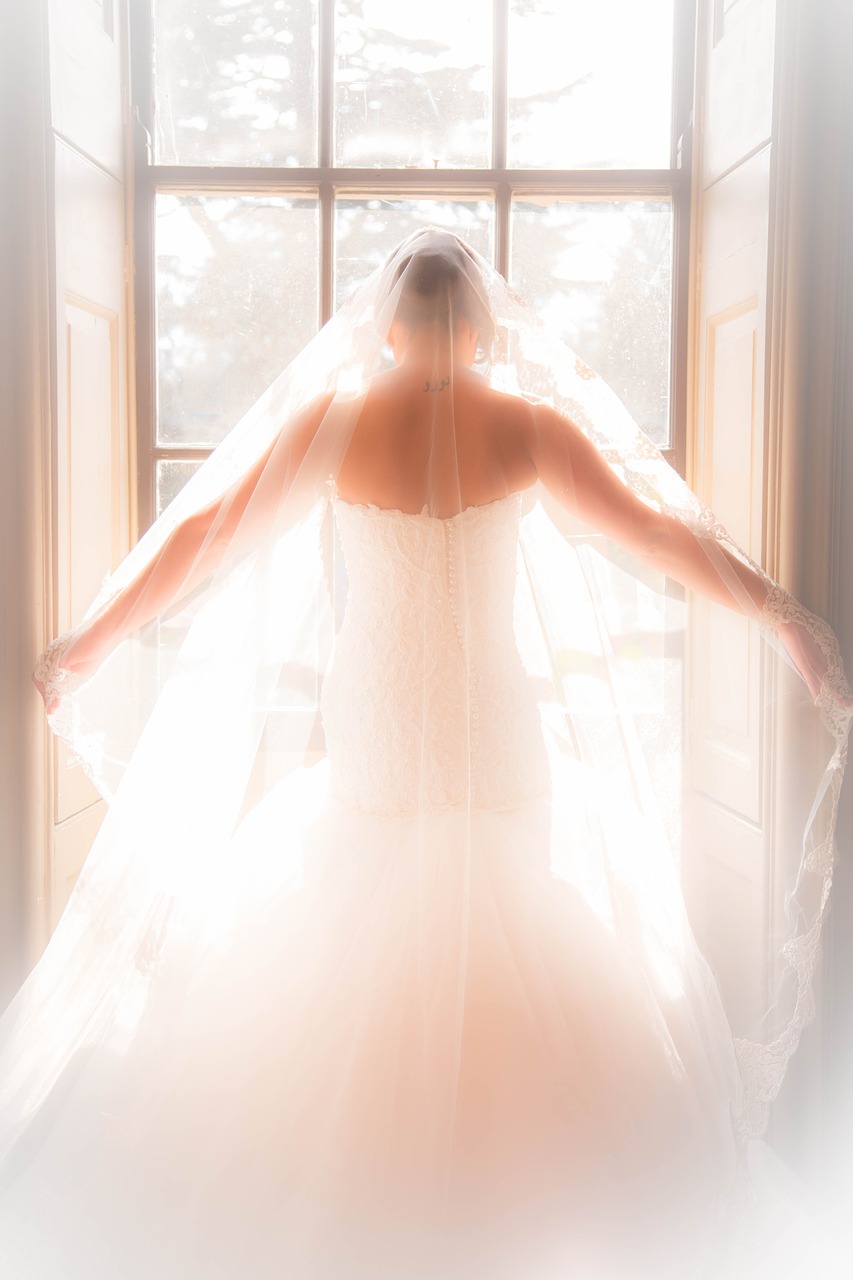 Bride standing in a window.