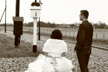 Couple waiting for a train with their luggage.