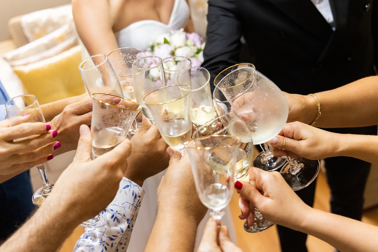 Bride, groom, and wedding guests toasting.