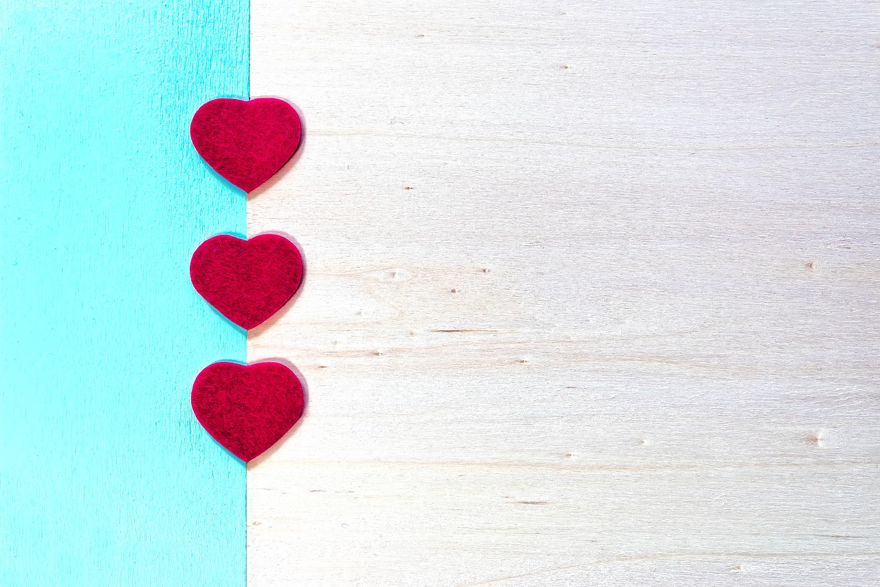 Wedding invitation with three red hearts.