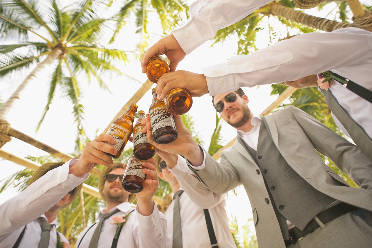 Groomsmen toasting with bottles of beer.