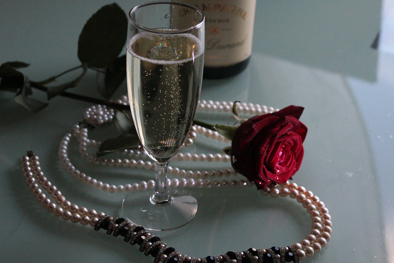 Champagne with pearls and a red rose.