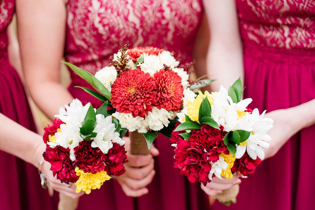 Bridesmaids in deep red gowns.